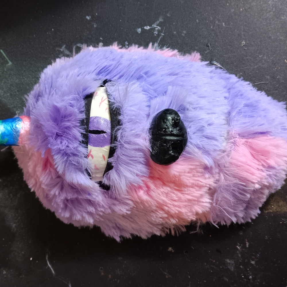 Unique Pink furry monster mask with one horn called uni monsters it is one of a